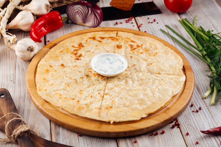 caucasian traditional thin flatbread khychin with sour cream sauce wooden table_219193 4513